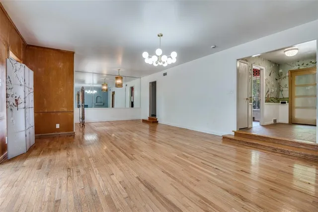 a view of a room with wooden floor and a kitchen