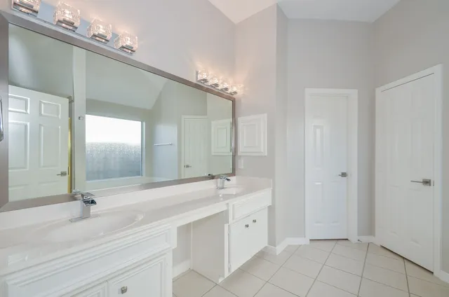 a spacious bathroom with a tub sink and mirror