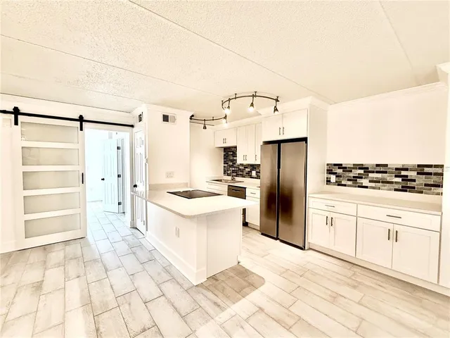 a large kitchen with cabinets and stainless steel appliances