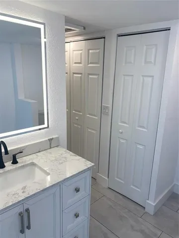 a bathroom with a granite countertop sink a mirror and a shower