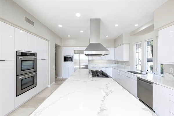 a kitchen with granite countertop a sink stainless steel appliances and cabinets