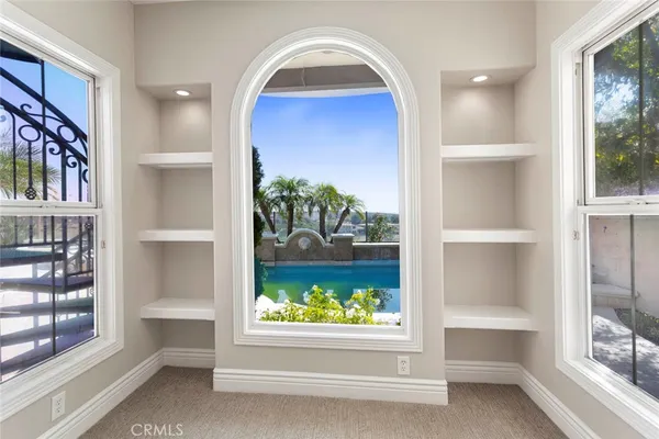a view of a hallway with wooden floor and a window