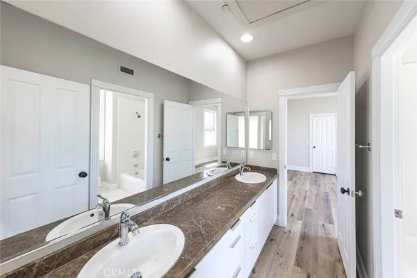 a spacious bathroom with a granite countertop tub sink and mirror