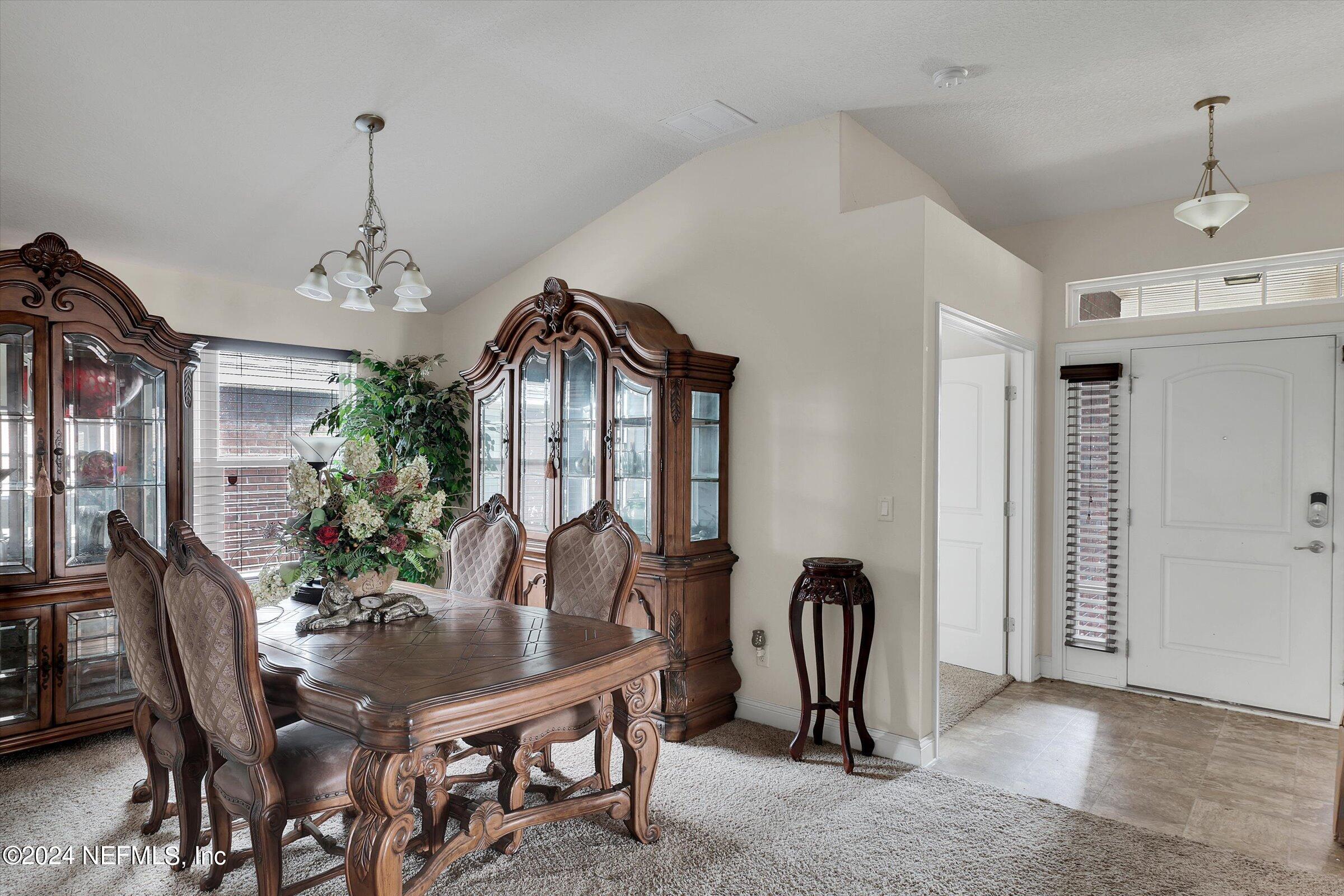 2109 Cherokee Cove Trail Jacksonville, FL 32221 - Photo 11 of 29 a view of a dining room with furniture and chandelier