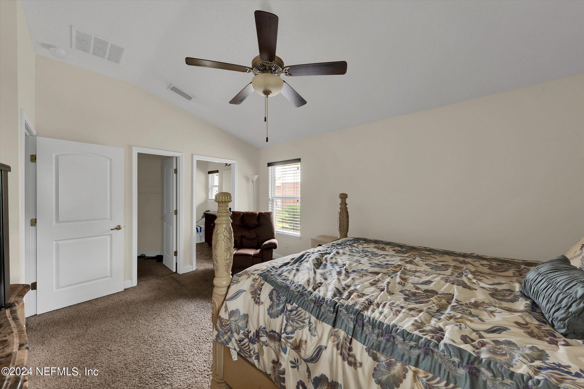 2109 Cherokee Cove Trail Jacksonville, FL 32221 - Photo 22 of 29 a bedroom with a bed and a chandelier