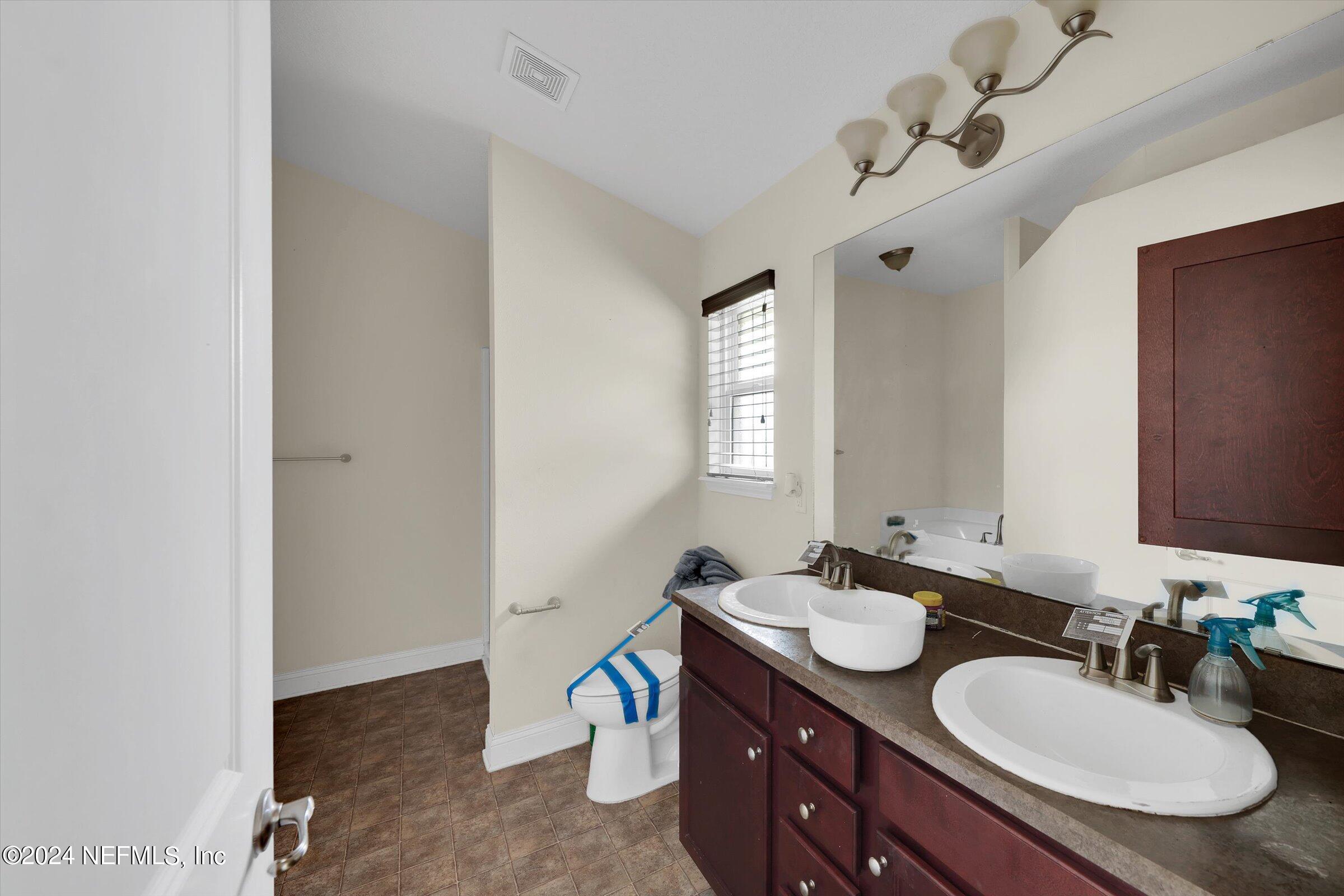 2109 Cherokee Cove Trail Jacksonville, FL 32221 - Photo 23 of 29 a bathroom with a granite countertop sink a mirror and a vanity