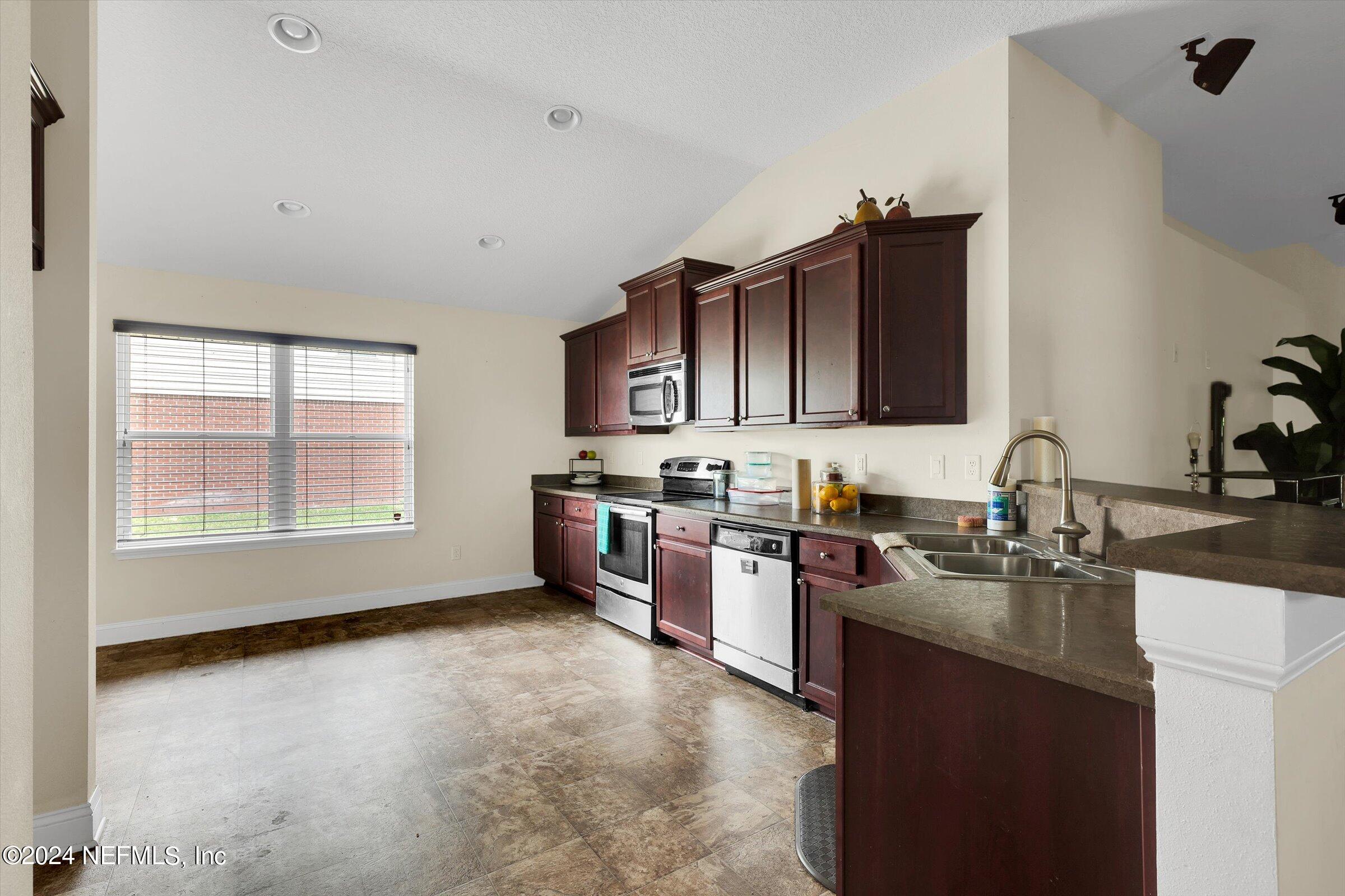 2109 Cherokee Cove Trail Jacksonville, FL 32221 - Photo 5 of 29 a kitchen with stainless steel appliances granite countertop a stove sink microwave and cabinets