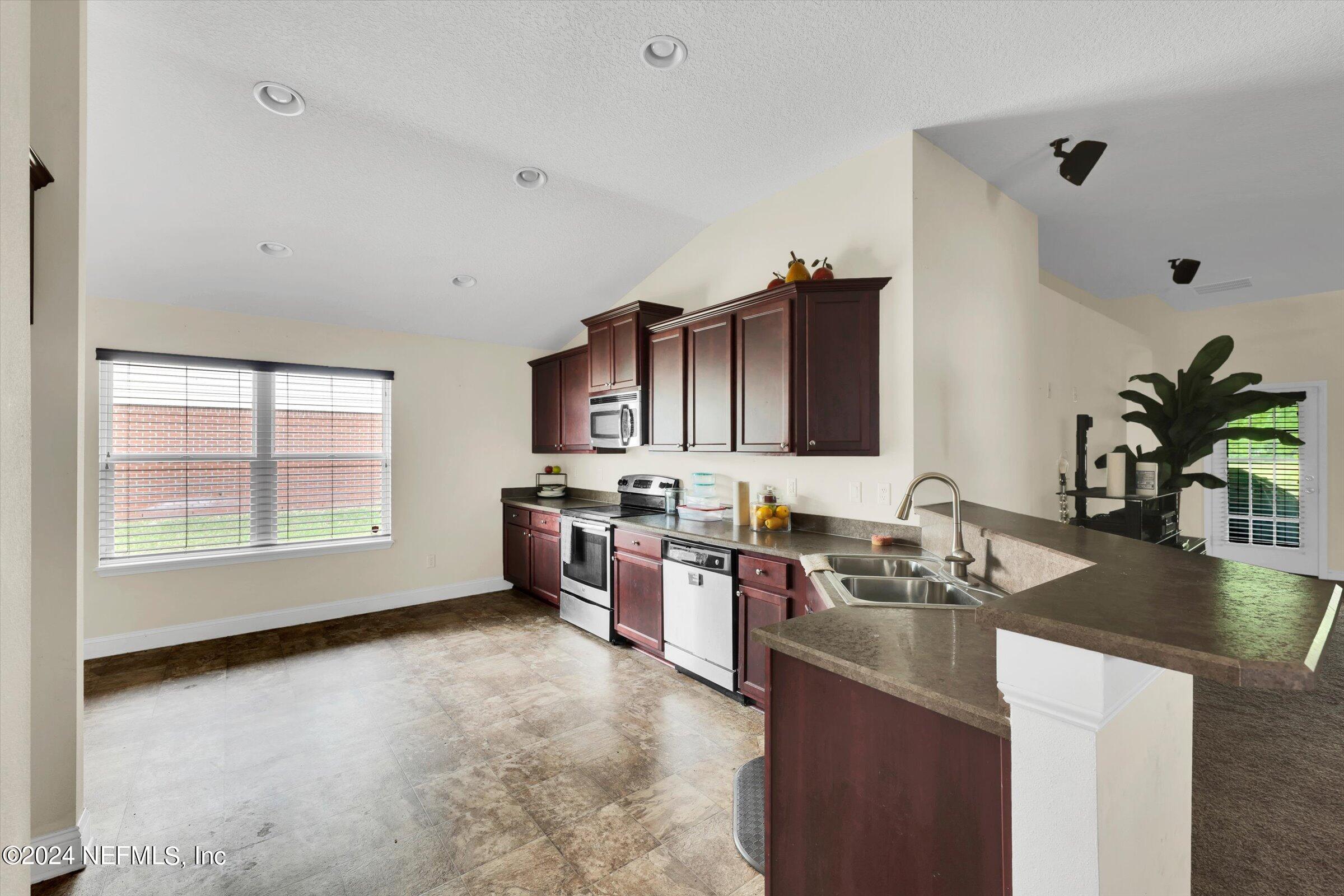 2109 Cherokee Cove Trail Jacksonville, FL 32221 - Photo 7 of 29 a kitchen with a sink stove and cabinets