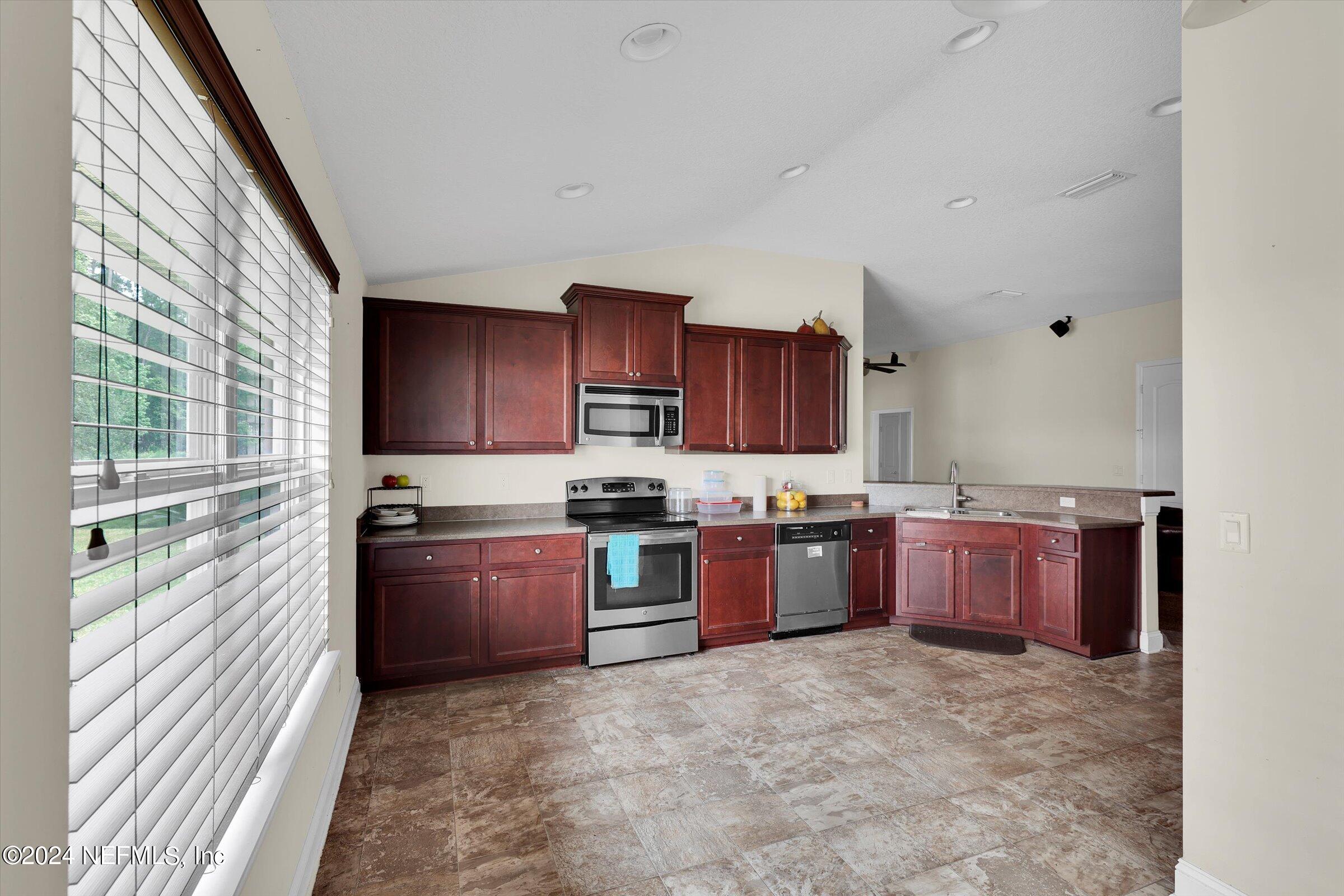 2109 Cherokee Cove Trail Jacksonville, FL 32221 - Photo 8 of 29 a kitchen with stainless steel appliances granite countertop a stove sink and cabinets