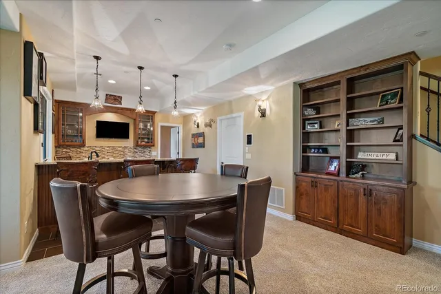 a kitchen with stainless steel appliances a dining table chairs microwave and refrigerator