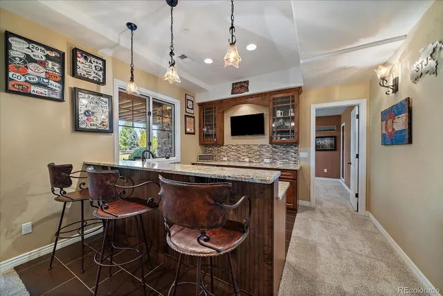 a open kitchen with stainless steel appliances granite countertop a stove a refrigerator a kitchen island a dining table and chairs with wooden floor
