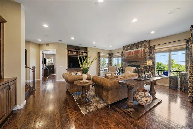 a living room with furniture a wooden floor and a large window
