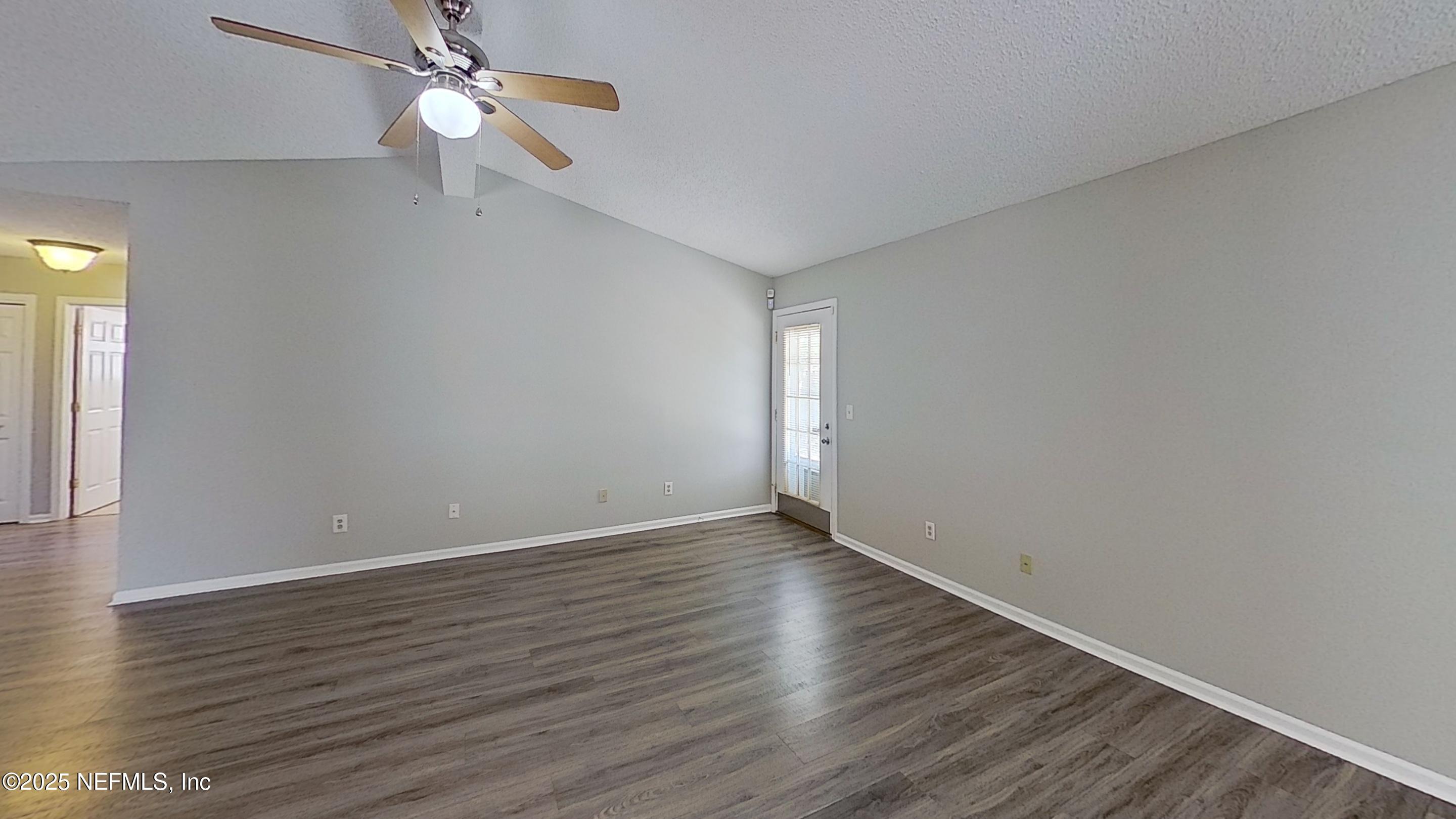 1639 Spring Branch Drive West Jacksonville, FL 32221 - Photo 5 of 25 an empty room with wooden floor fan and windows