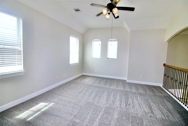 an empty room with windows and fan