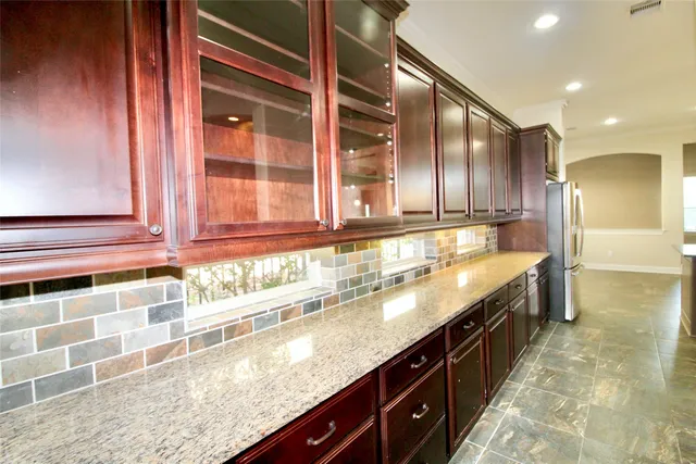 a kitchen with stainless steel appliances granite countertop a sink a stove and a refrigerator