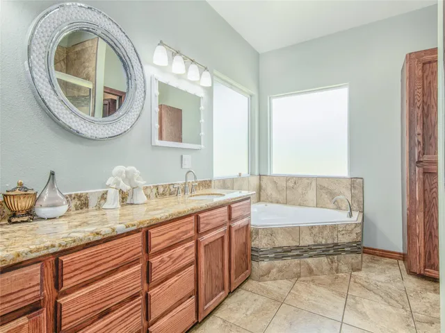 a bathroom with a granite countertop shower a mirror and a sink
