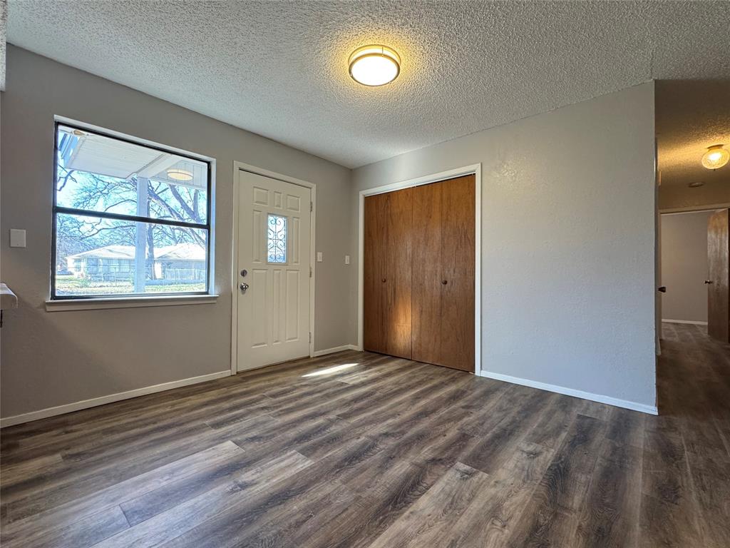 205 Wight Street Roxton, TX 75477 - Photo 13 of 22 an empty room with wooden floor and windows