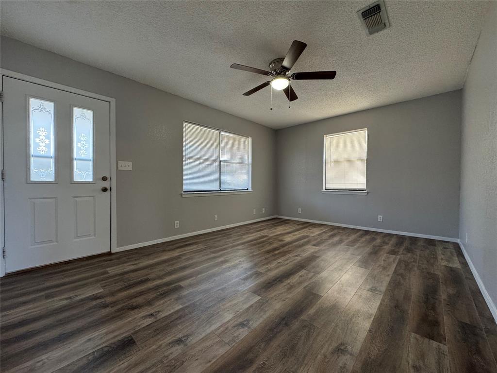 205 Wight Street Roxton, TX 75477 - Photo 2 of 22 a view of empty room with wooden floor and fan