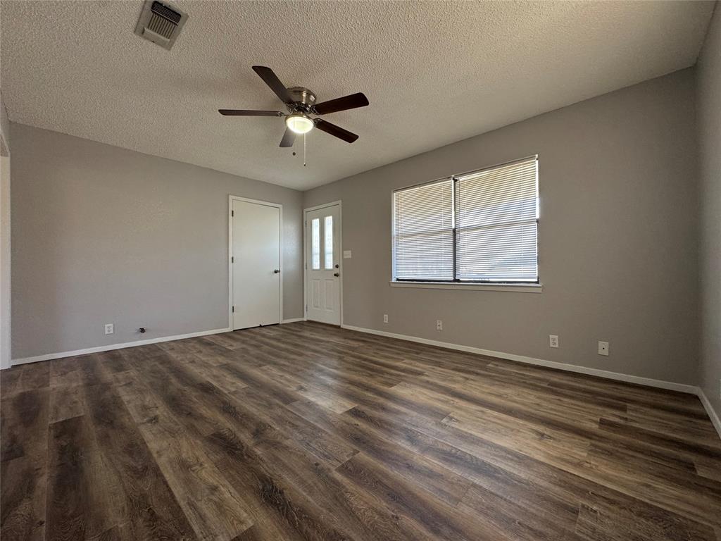 205 Wight Street Roxton, TX 75477 - Photo 3 of 22 a view of an empty room with wooden floor and a window