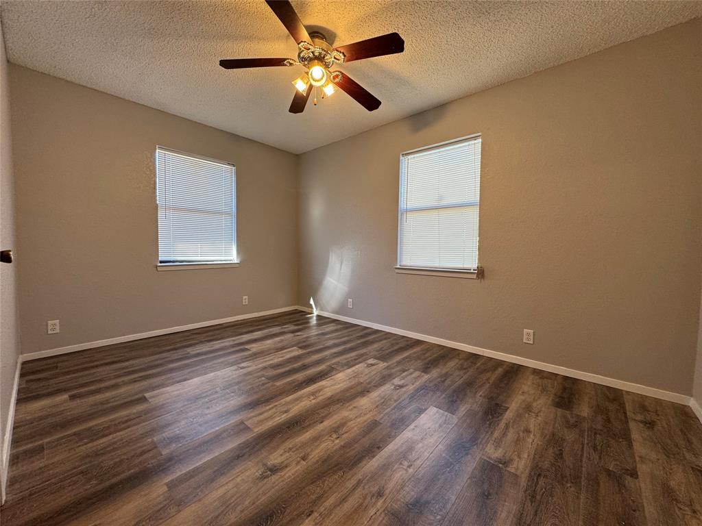 205 Wight Street Roxton, TX 75477 - Photo 10 of 22 a view of an empty room with wooden floor and a window