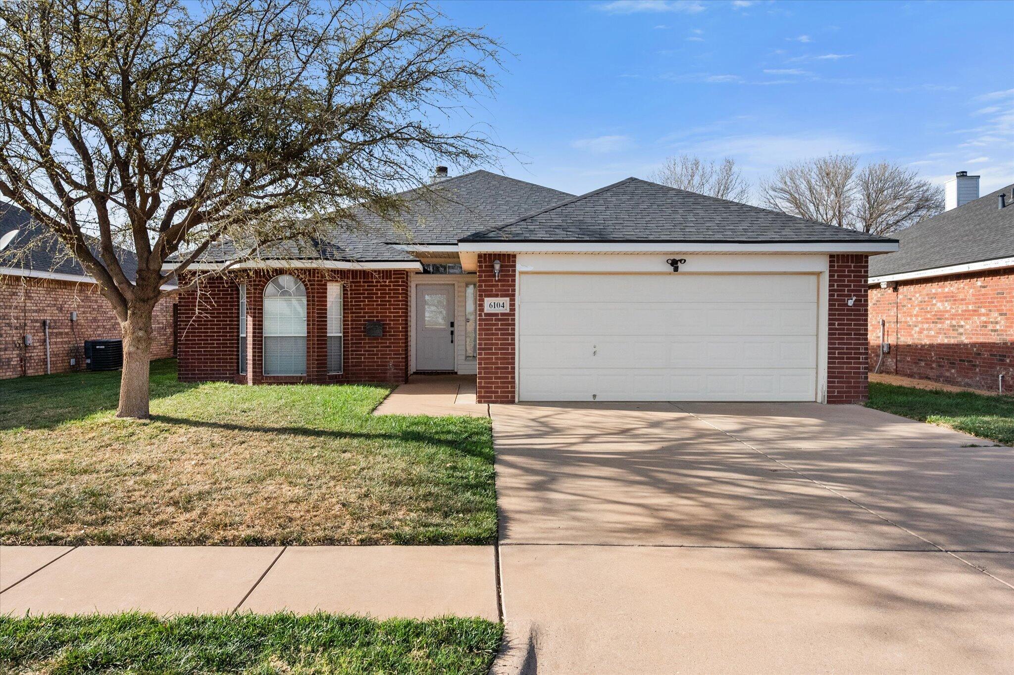6104 Duke Street Lubbock, TX 79416 - Photo 1 of 28 a front view of a house with a yard and garage