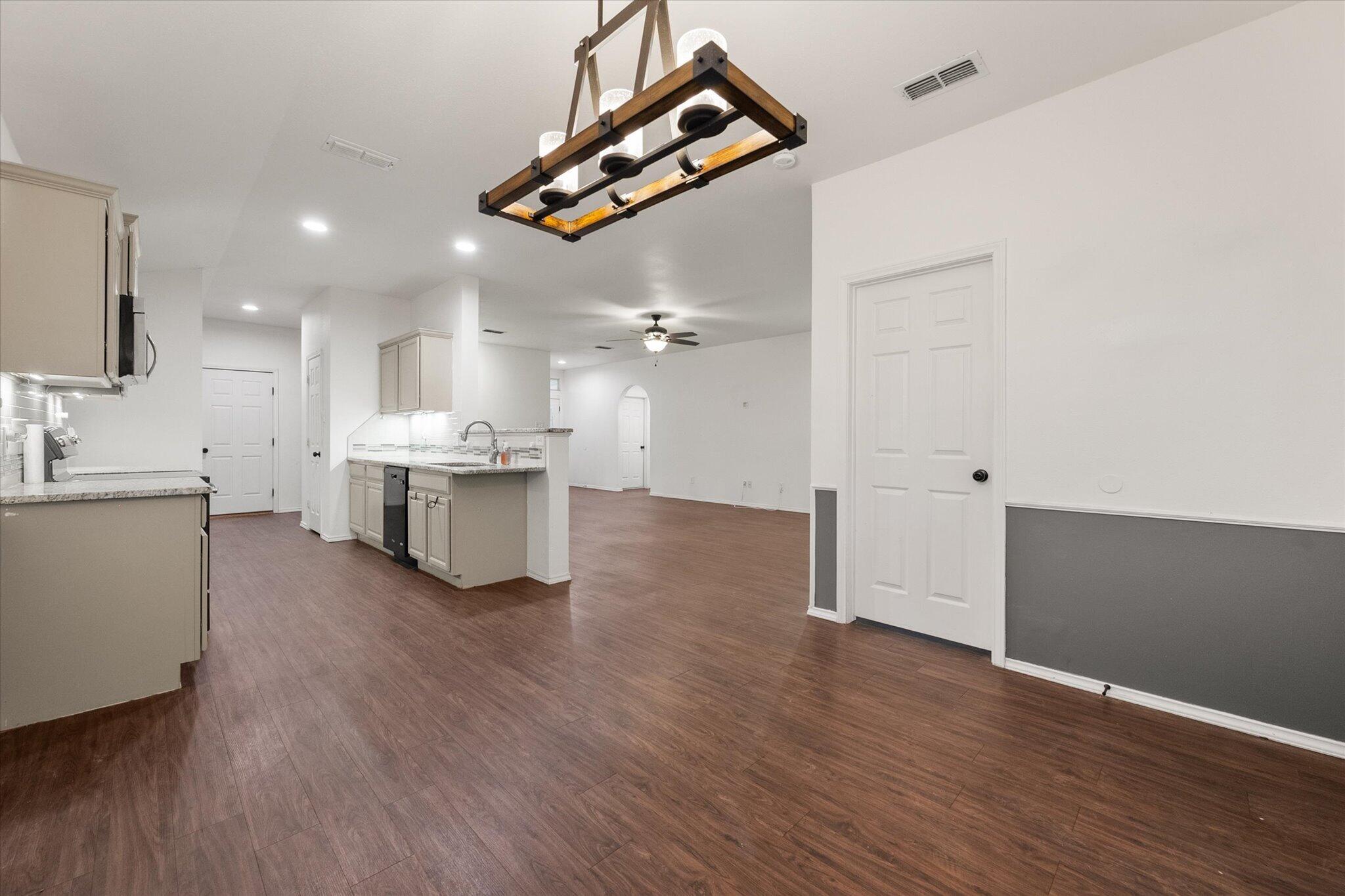 6104 Duke Street Lubbock, TX 79416 - Photo 20 of 28 a living room with kitchen island furniture and wooden floor