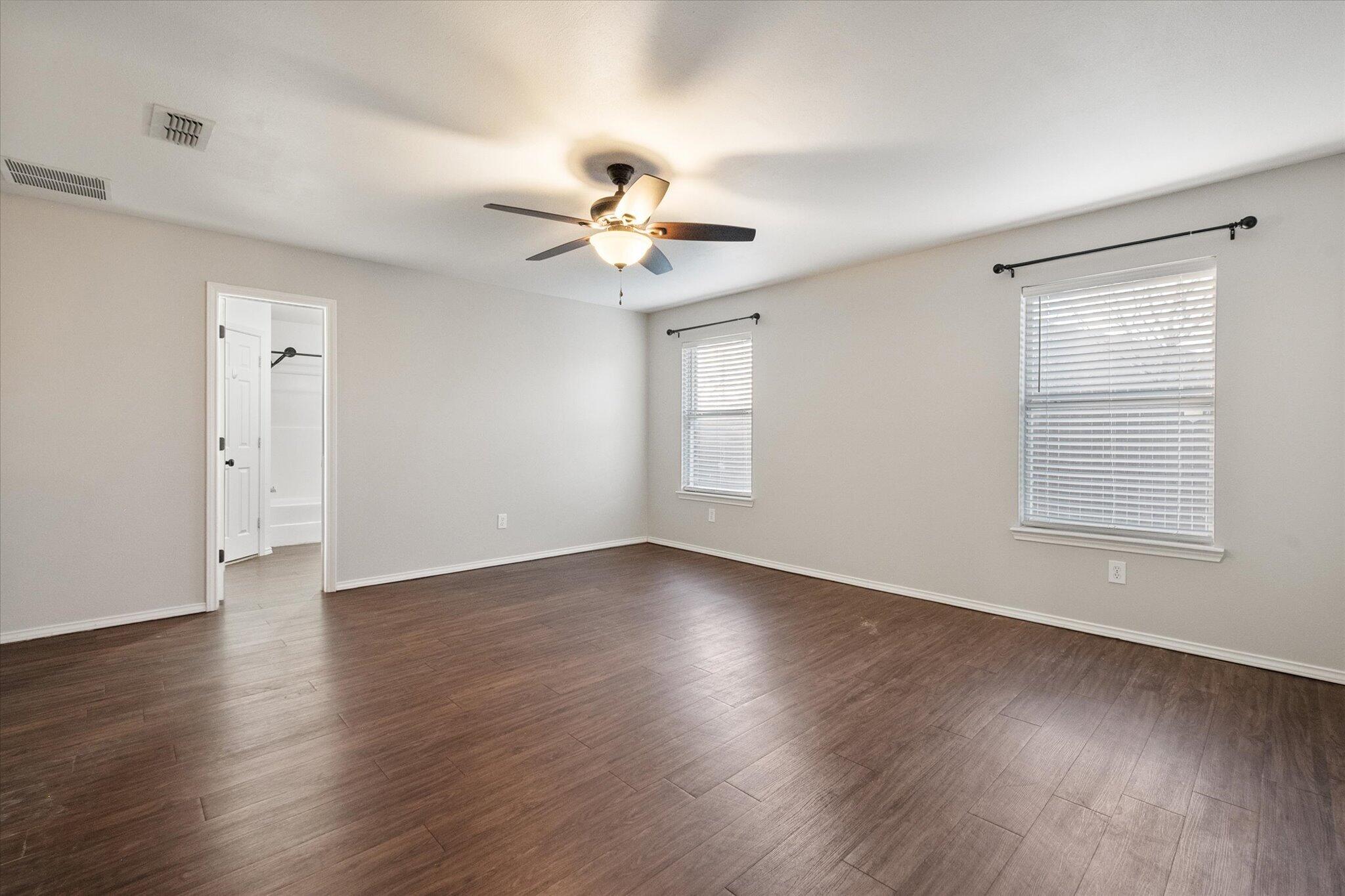 6104 Duke Street Lubbock, TX 79416 - Photo 21 of 28 a view of an empty room with a window and wooden floor