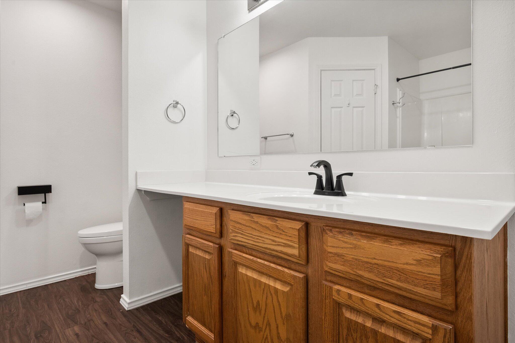 6104 Duke Street Lubbock, TX 79416 - Photo 24 of 28 a bathroom with a sink a toilet a mirror and shower