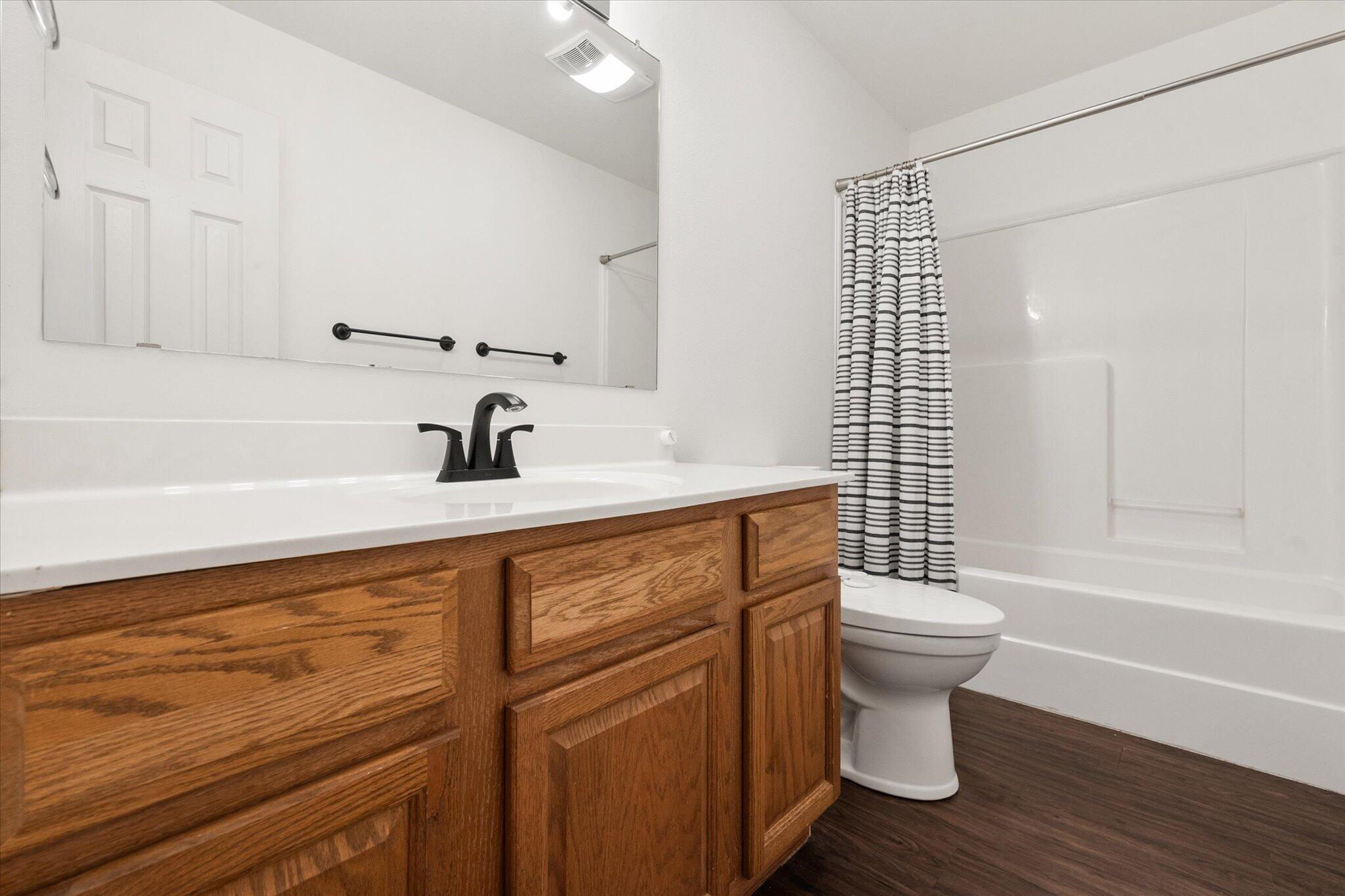 6104 Duke Street Lubbock, TX 79416 - Photo 6 of 28 a bathroom with a sink a toilet and shower