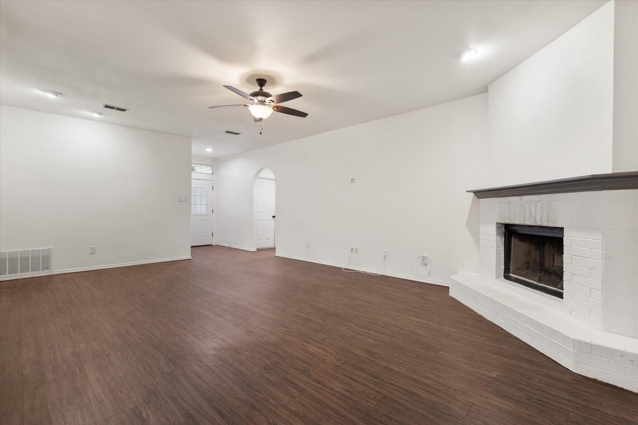 6104 Duke Street Lubbock, TX 79416 - Photo 10 of 28 a view of empty room with wooden floor and fireplace