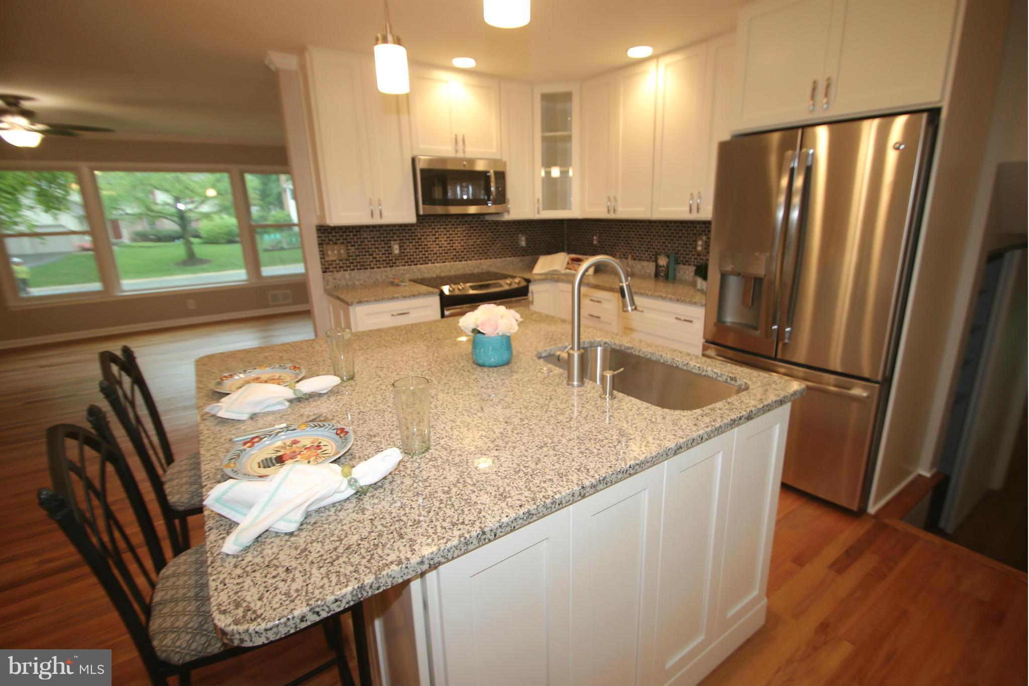 3405 Briars Road Brookeville, MD 20833 - Photo 3 of 21 a kitchen with stainless steel appliances granite countertop a sink a refrigerator a stove a microwave oven with a dining table and chairs