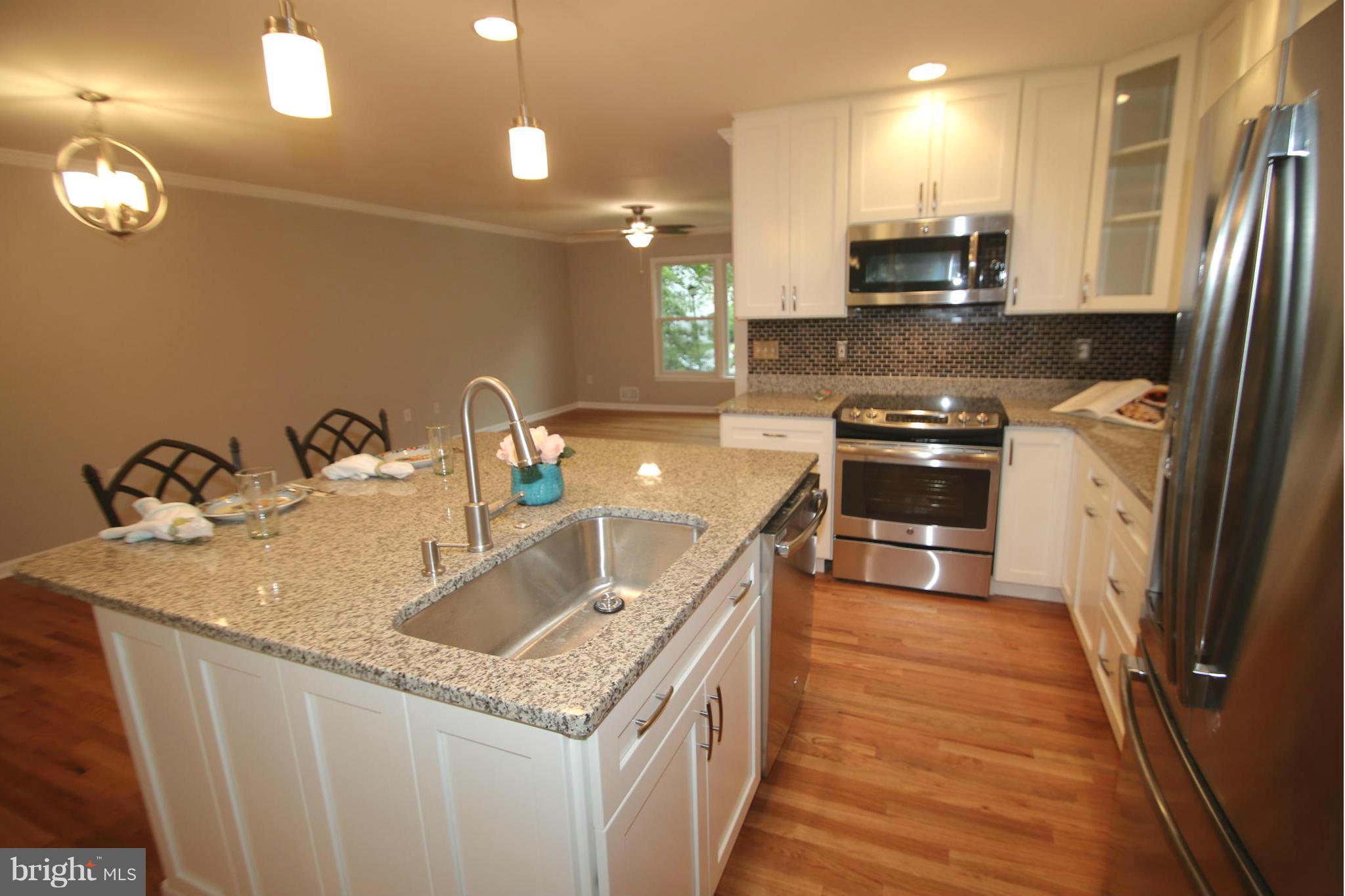 3405 Briars Road Brookeville, MD 20833 - Photo 4 of 21 a kitchen with stainless steel appliances granite countertop a sink a stove top oven a refrigerator cabinets and wooden floor