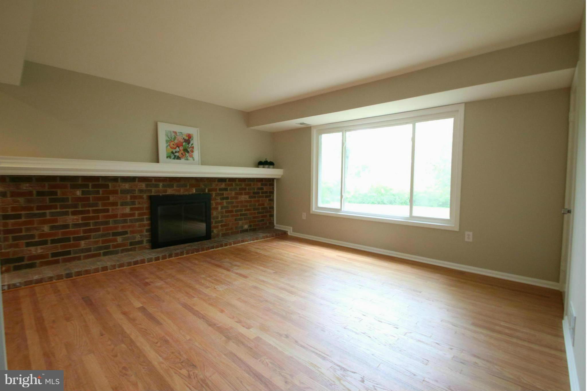 3405 Briars Road Brookeville, MD 20833 - Photo 6 of 21 a view of empty room with wooden floor and fireplace