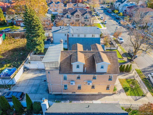 an aerial view of residential houses with outdoor space and parking