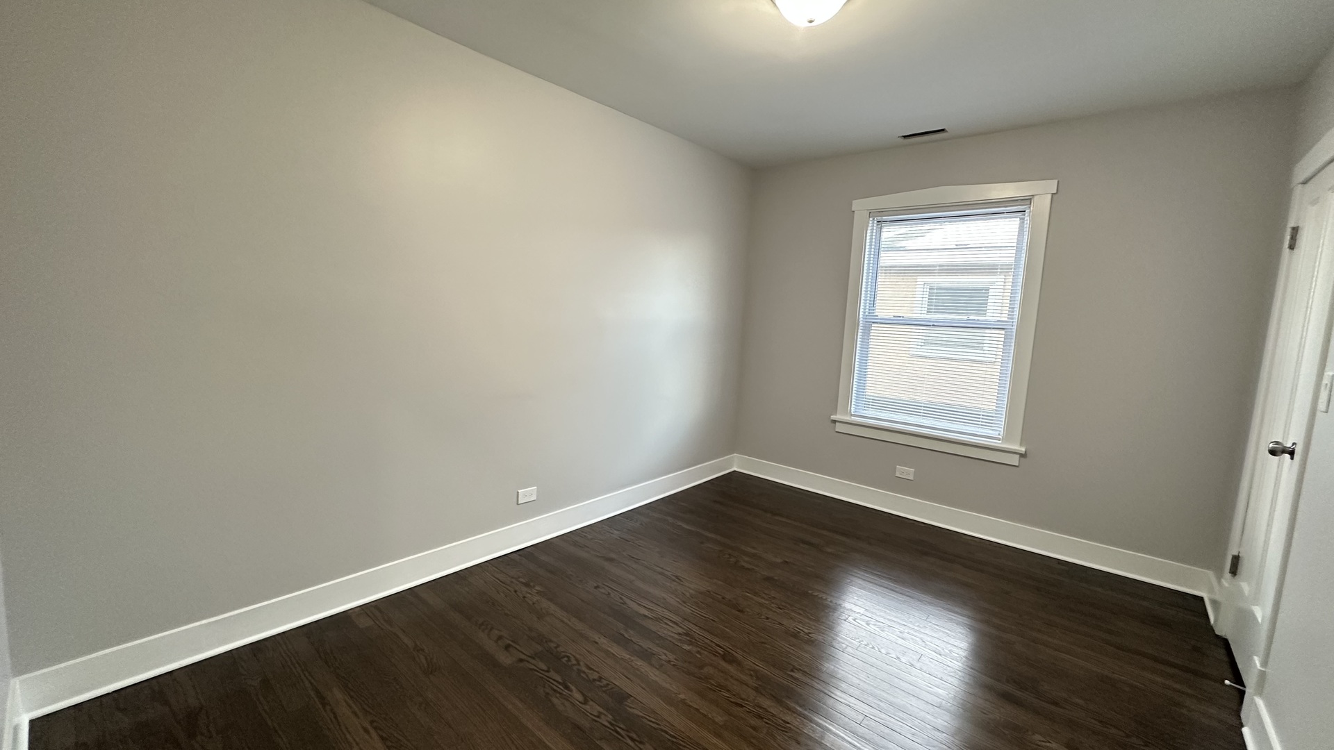 5226 North Bernard Street, Unit 2 Chicago, IL 60625 - Photo 4 of 12 an empty room with wooden floor and windows