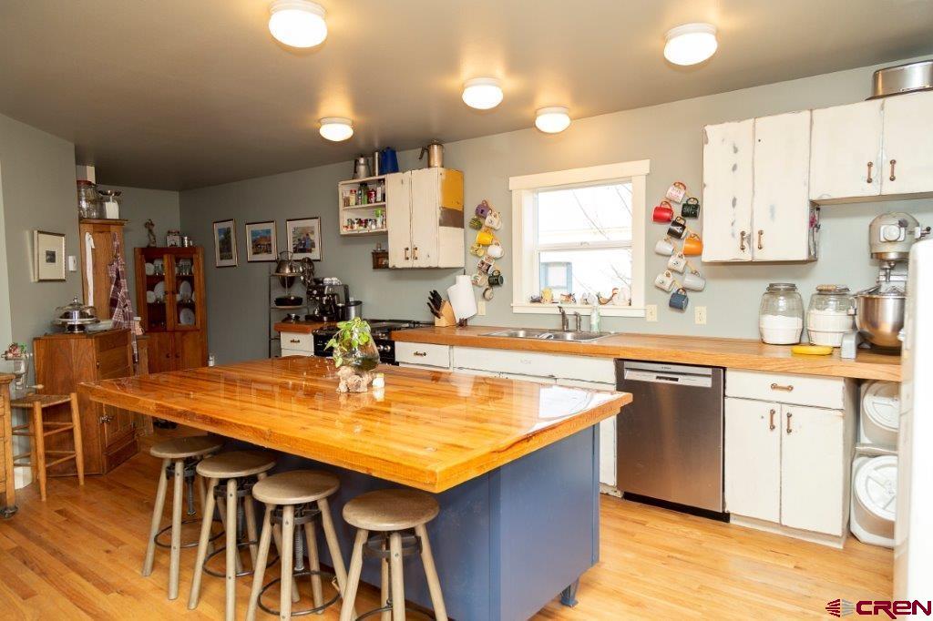 301 West 3rd Street Creede, CO 81130 - Photo 2 of 17 a kitchen with stainless steel appliances granite countertop a kitchen island a stove a sink dishwasher and cabinets with wooden floor