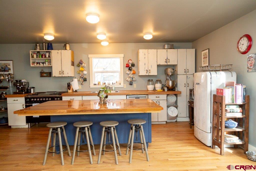 301 West 3rd Street Creede, CO 81130 - Photo 3 of 17 a kitchen with stainless steel appliances granite countertop a table chairs sink and cabinets