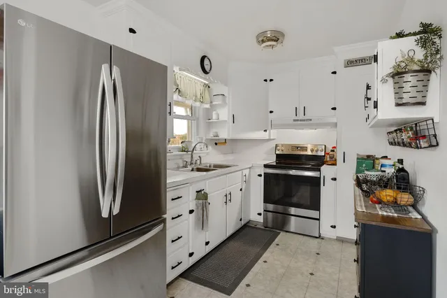 a kitchen with stainless steel appliances a refrigerator sink and cabinets