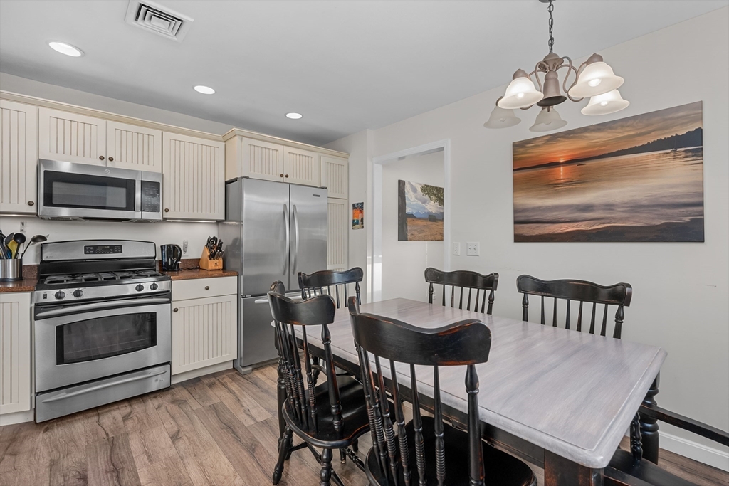 17 Maple Street Bourne, MA 02532 - Photo 16 of 33 a kitchen with stainless steel appliances granite countertop a stove a refrigerator a kitchen island a dining table and chairs