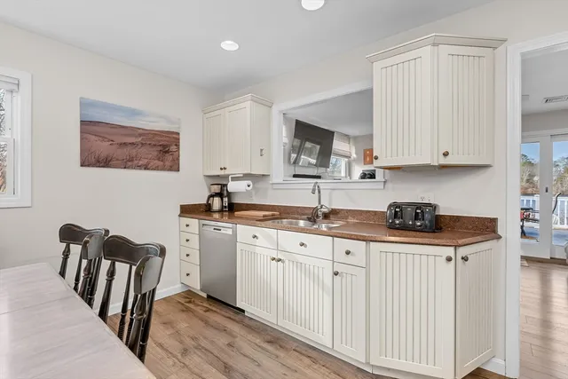 a view of a dining room with furniture a chandelier and wooden floor
