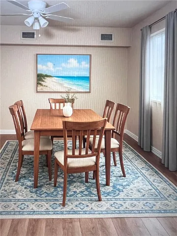 an empty room with a chandelier fan and windows