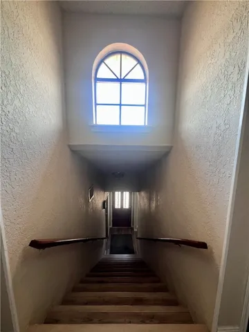 a view of a hallway with wooden floor and staircase