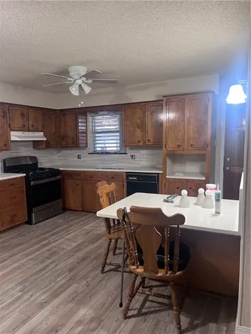 a kitchen with a table chairs sink and cabinets