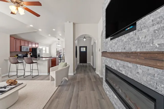 a kitchen with stainless steel appliances granite countertop a stove top oven a sink dishwasher a dining table and chairs with wooden floor