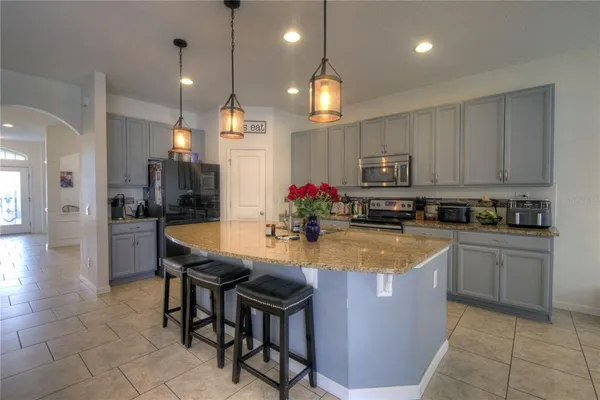 a kitchen with stainless steel appliances granite countertop wooden cabinets a dining table and chairs