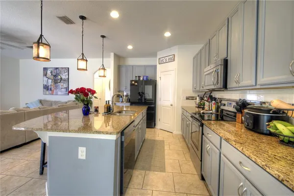 a kitchen with stainless steel appliances granite countertop a sink a oven and a refrigerator
