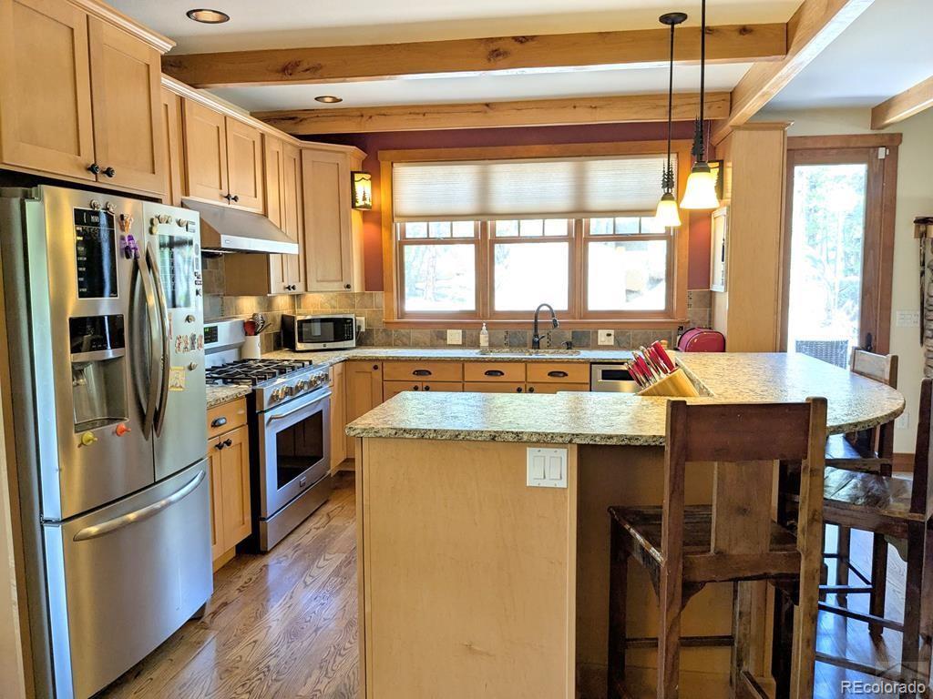 10 Robert Road Rye, CO 81069 - Photo 11 of 50 a kitchen with stainless steel appliances granite countertop a stove a refrigerator and a dining table
