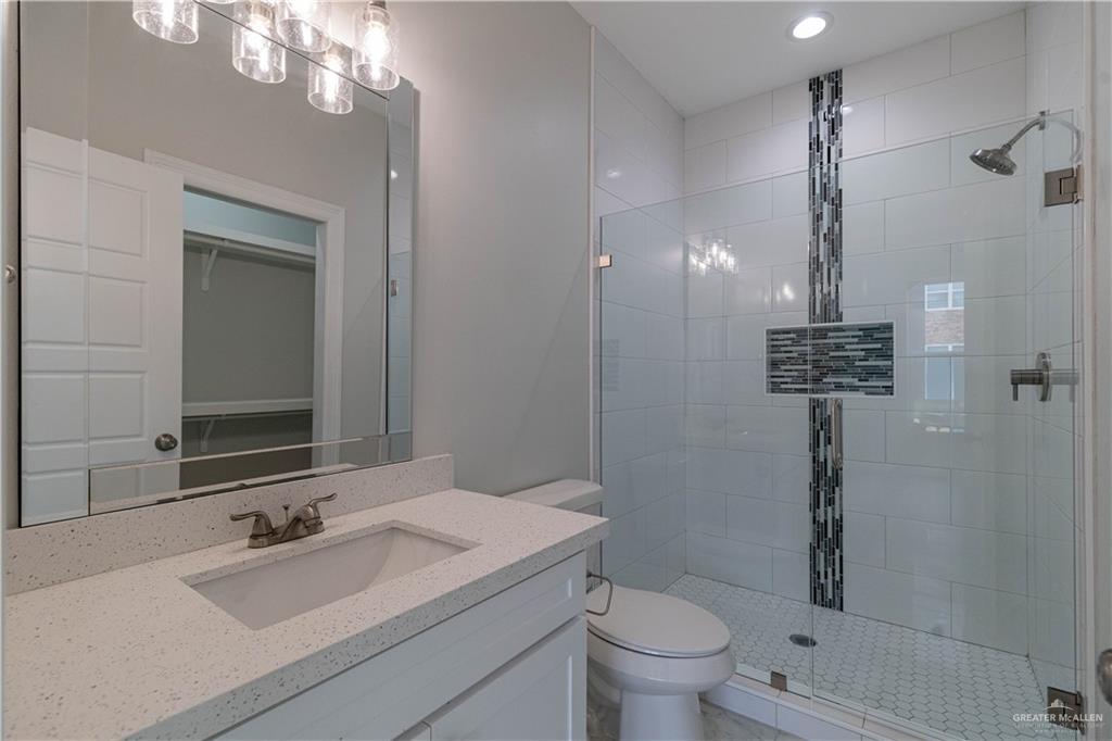 5404 North Crown Point Pharr, TX 78577 - Photo 17 of 24 a bathroom with a sink a toilet a mirror and shower