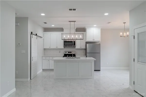 a kitchen with stainless steel appliances a refrigerator sink and stove