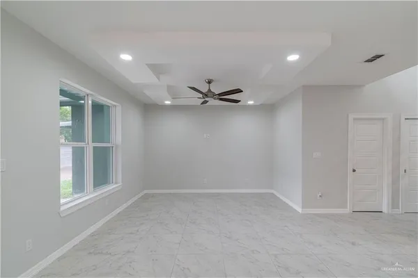an empty room with a window and a ceiling fan